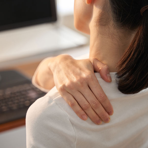 woman grasping her shoulder